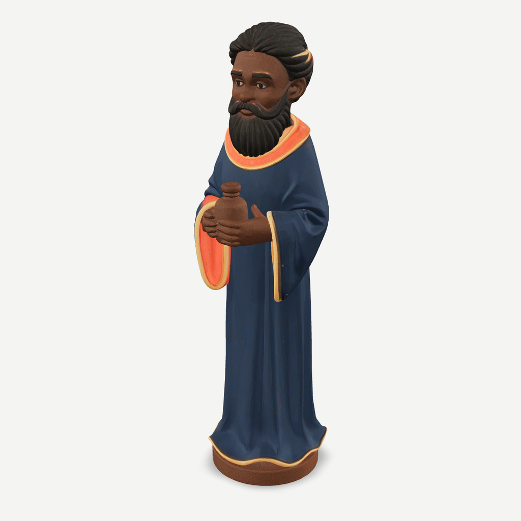 3D printed nativity figurine of Balthazar standing with a jar of myrrh, navy robe and crown — front quarter view